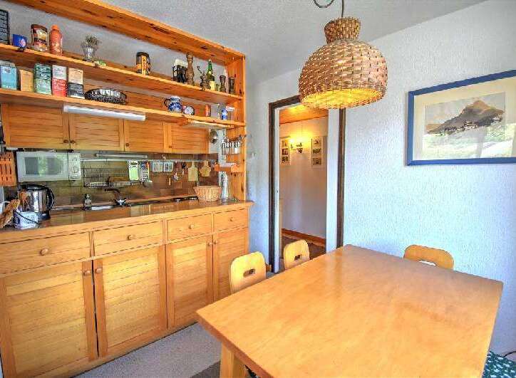 This charming kitchen features warm wooden cabinetry and open shelving, providing ample storage and display space.
