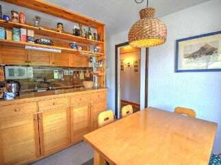 This charming kitchen features warm wooden cabinetry and open shelving, providing ample storage and display space.