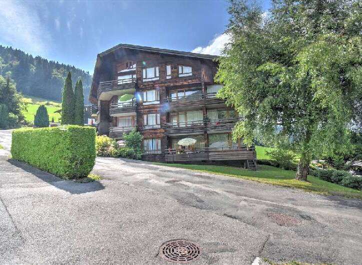 Discover this charming multi-story wooden building nestled in a picturesque mountain landscape.