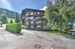 Discover this charming multi-story wooden building nestled in a picturesque mountain landscape.
