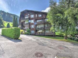 Discover this charming multi-story wooden building nestled in a picturesque mountain landscape.