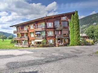 Experience alpine living in this charming wooden apartment building, nestled amidst lush green hills and picturesque mountain scenery.