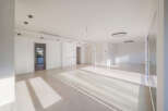 This spacious, modern apartment features an open-concept living area bathed in natural light from large windows.
