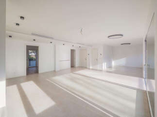 This spacious, modern apartment features an open-concept living area bathed in natural light from large windows.