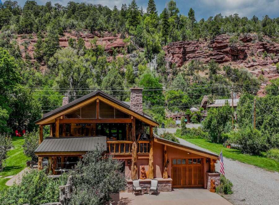 Nestled against a stunning red rock cliff face, this rustic log home offers unparalleled natural beauty and serene living.
