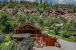 Nestled against a stunning red rock cliff face, this rustic log home offers unparalleled natural beauty and serene living.