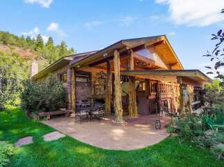 Experience rustic charm and mountain living in this unique log-accented home, nestled against a scenic hillside.