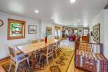 Experience rustic charm in this spacious dining and living area, featuring a live-edge dining table perfect for gatherings and a cozy fireplace in the adjacent living room.