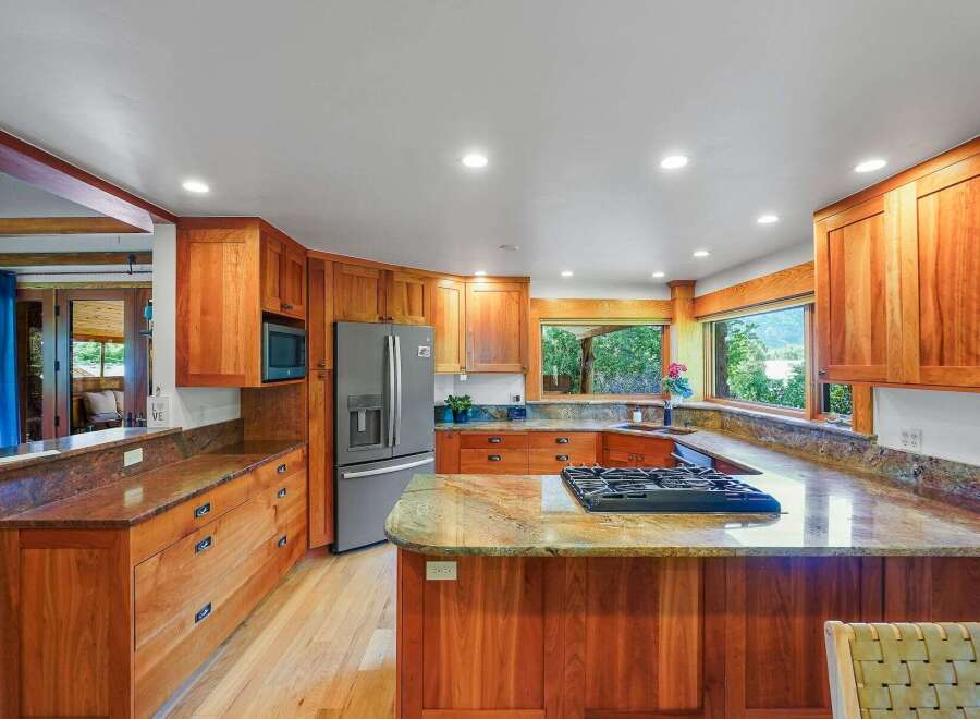 Experience the warmth of this beautifully appointed kitchen, featuring custom cherry wood cabinetry and granite countertops.