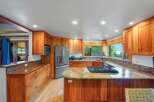 Experience the warmth of this beautifully appointed kitchen, featuring custom cherry wood cabinetry and granite countertops.
