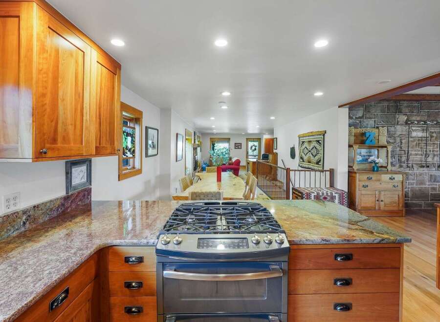 Experience the heart of this home with a spacious kitchen featuring warm cherry wood cabinets and stunning granite countertops.