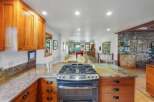 Experience the heart of this home with a spacious kitchen featuring warm cherry wood cabinets and stunning granite countertops.