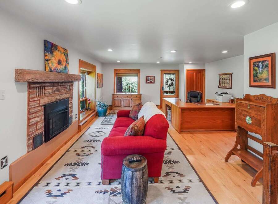 This inviting living space features a rustic stone fireplace as its centerpiece, complemented by a vibrant sunflower artwork.