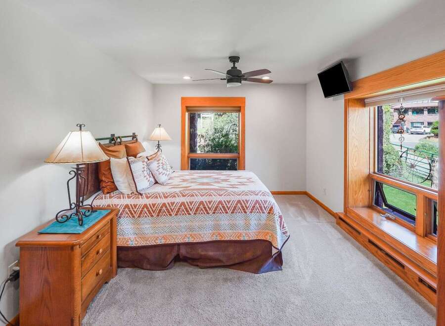 This charming bedroom features a cozy queen-size bed adorned with a Southwestern-inspired quilt and decorative pillows.