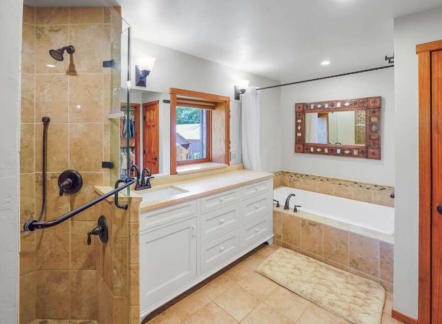 This spacious bathroom features a luxurious walk-in shower with elegant tilework and a convenient handheld showerhead.