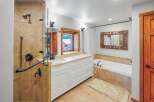 This spacious bathroom features a luxurious walk-in shower with elegant tilework and a convenient handheld showerhead.