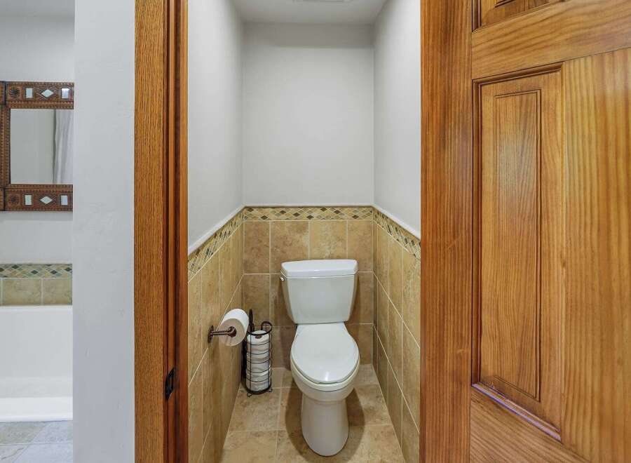 This bathroom features a stylish toilet with a decorative tile accent wall, offering a clean and functional space.