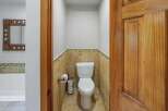 This bathroom features a stylish toilet with a decorative tile accent wall, offering a clean and functional space.