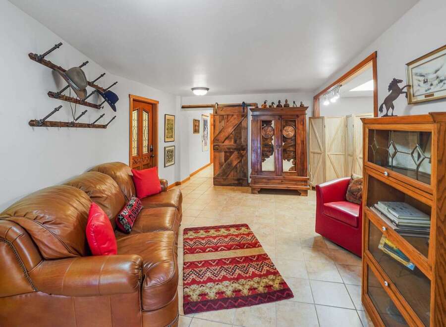Step into a rustic-inspired living space featuring a plush leather sofa complemented by a vibrant Southwestern rug.