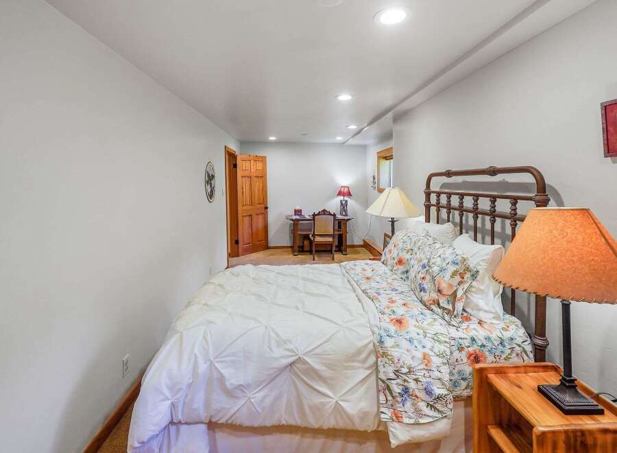 This charming bedroom features a comfortable queen-size bed with a floral duvet and a crisp white comforter, perfect for a restful night's sleep.