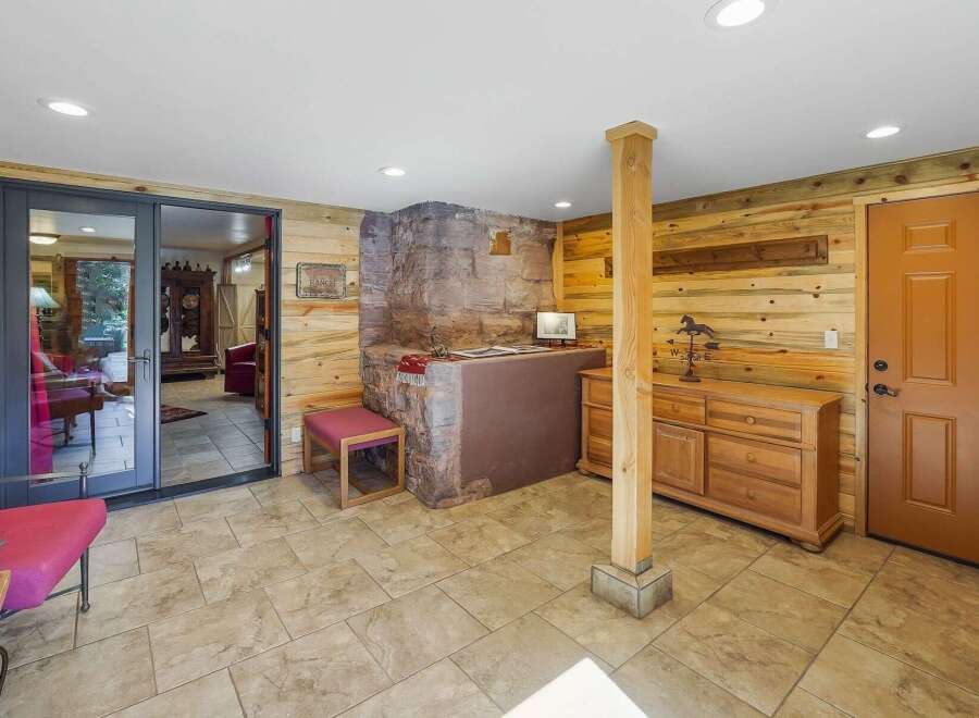 Step into a rustic retreat featuring warm wood paneling and a striking stone fireplace as the centerpiece.