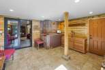 Step into a rustic retreat featuring warm wood paneling and a striking stone fireplace as the centerpiece.