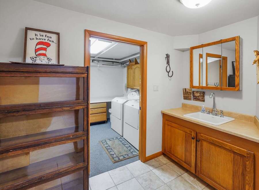 Discover a functional laundry room and a convenient vanity area, perfect for everyday living.