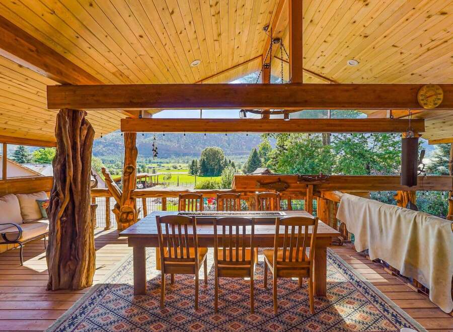 Experience rustic charm and breathtaking views from this covered outdoor dining area.