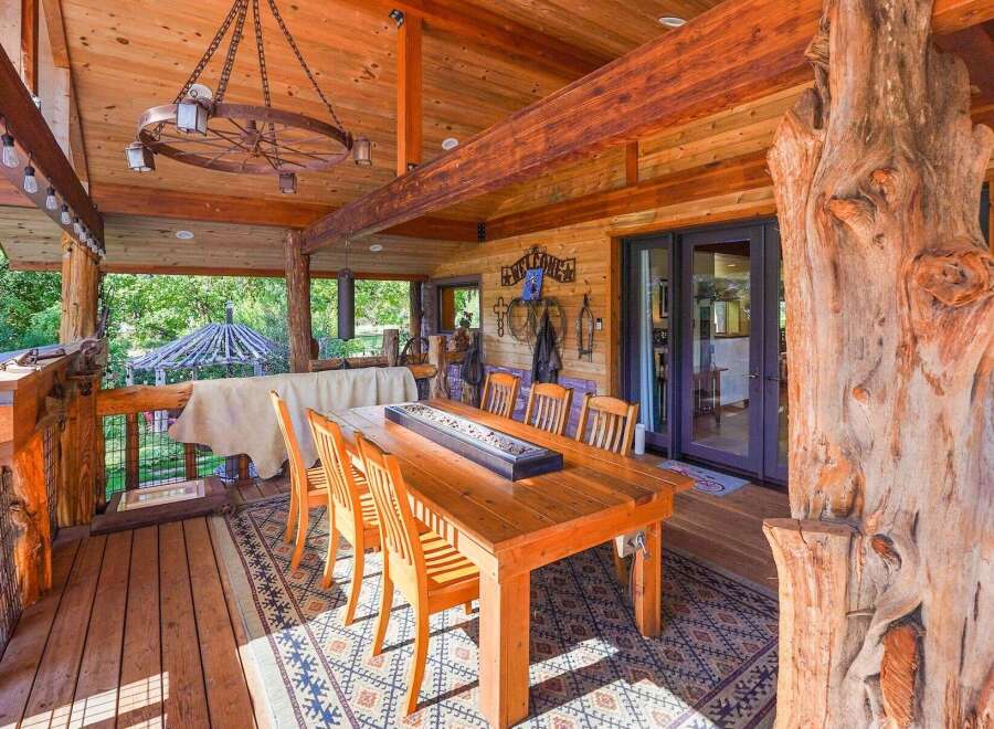 Experience rustic charm on this expansive covered porch, perfect for outdoor dining and entertaining.