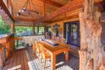 Experience rustic charm on this expansive covered porch, perfect for outdoor dining and entertaining.