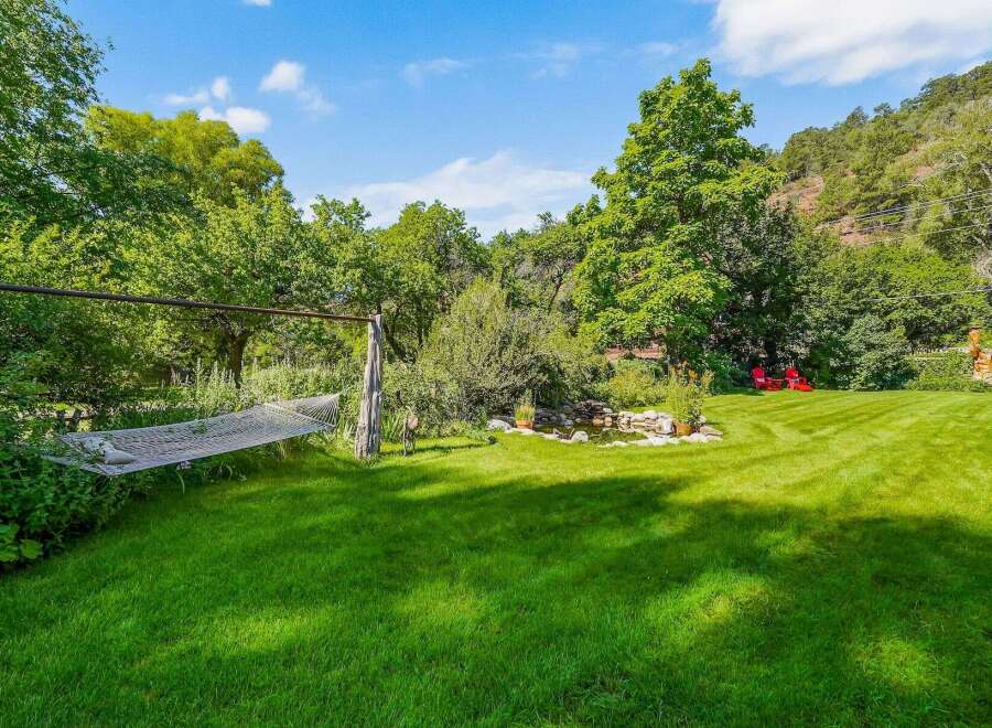 Escape to this serene backyard oasis, complete with a relaxing hammock perfect for unwinding.