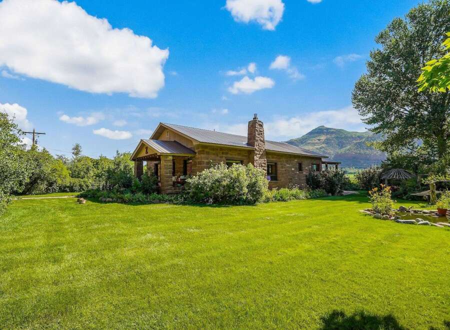 Nestled amidst lush greenery and rolling hills, this charming stone home offers a serene retreat.