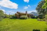 Nestled amidst lush greenery and rolling hills, this charming stone home offers a serene retreat.