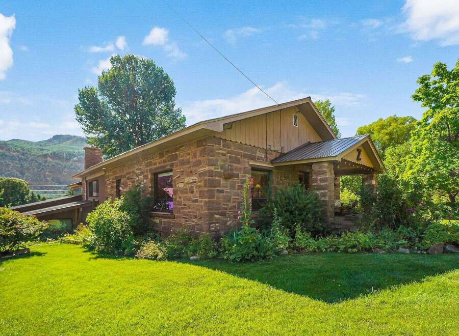 Discover this charming stone home nestled amidst lush greenery and scenic mountain views.