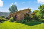 Discover this charming stone home nestled amidst lush greenery and scenic mountain views.
