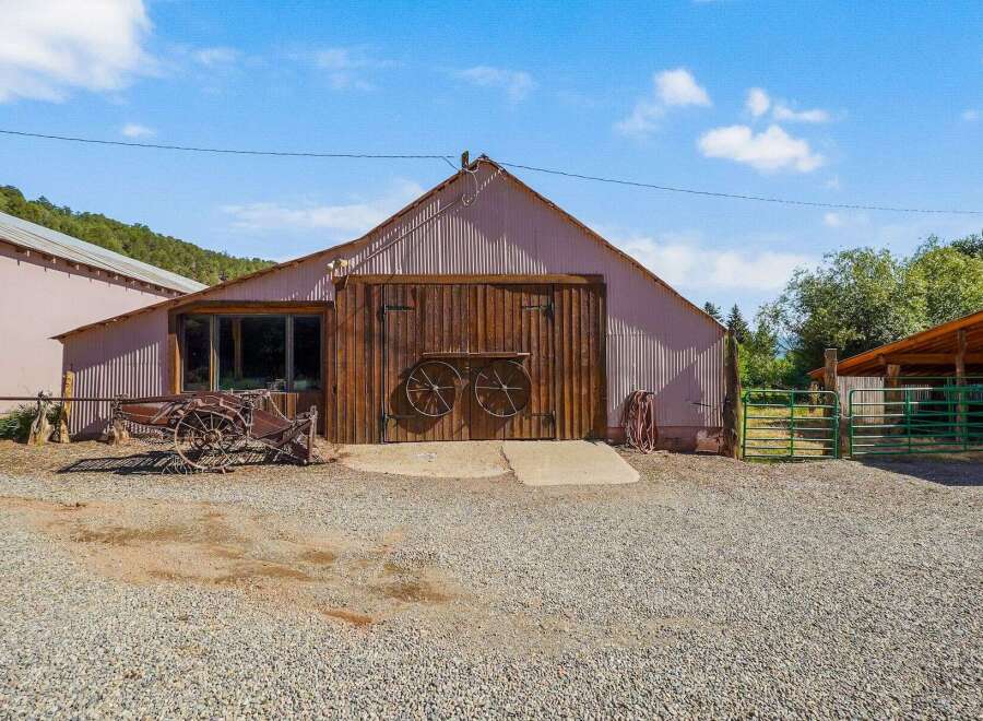 Discover this charming property featuring a rustic barn with large wooden doors, perfect for storage or conversion.