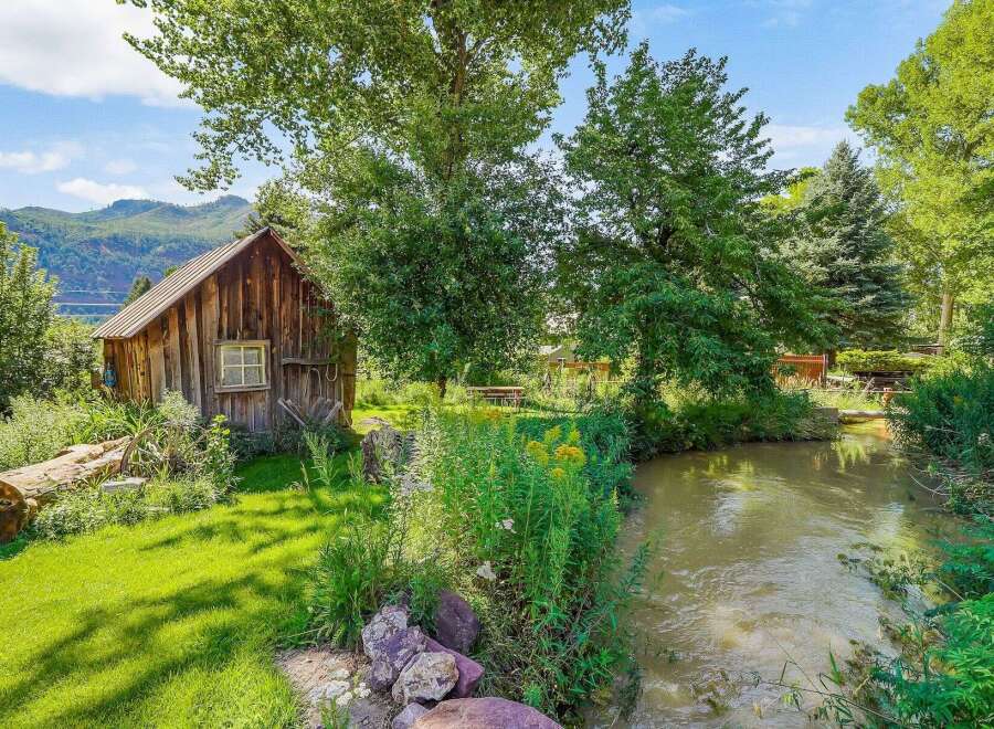 Escape to this charming rustic cabin nestled beside a serene creek, offering a tranquil retreat surrounded by lush greenery and mature trees.