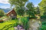 Escape to this charming rustic cabin nestled beside a serene creek, offering a tranquil retreat surrounded by lush greenery and mature trees.