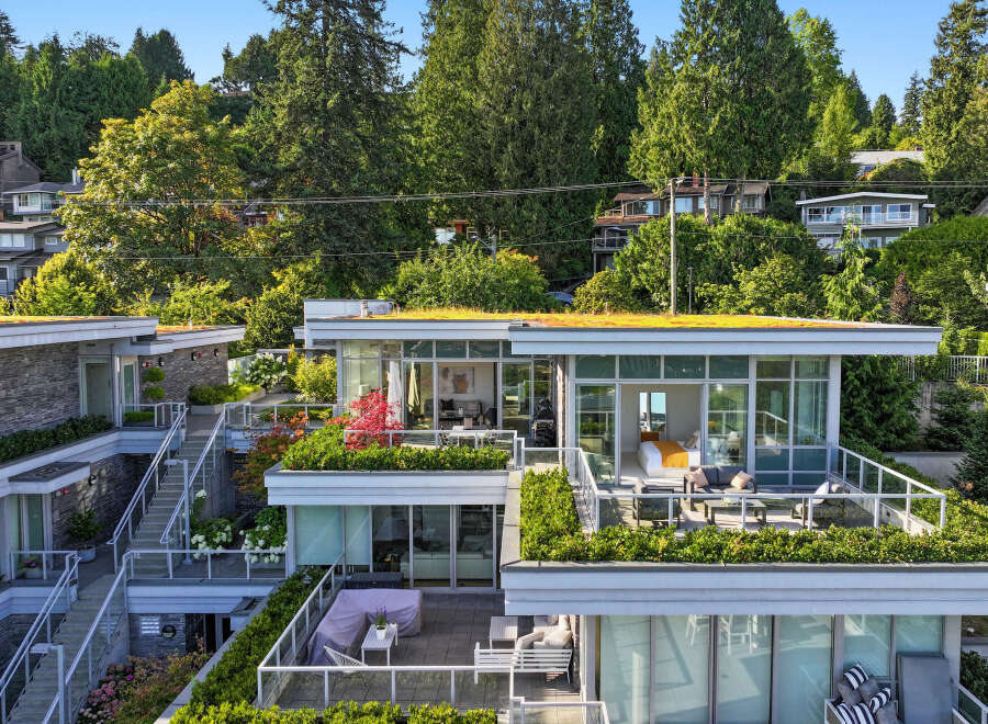 Experience modern luxury in this stunning multi-level residence featuring expansive balconies and lush green roofs.