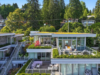Experience modern luxury in this stunning multi-level residence featuring expansive balconies and lush green roofs.