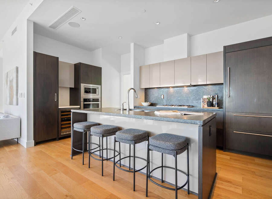 Experience modern luxury in this stunning kitchen, featuring sleek dark wood cabinetry and a spacious island with bar seating.