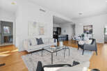 Experience modern living in this stunning open-concept space, featuring a sleek living area with a comfortable sofa and a stylish coffee table, seamlessly flowing into a contemporary kitchen with bar seating.