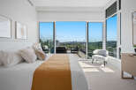 Experience luxurious urban living with this stunning bedroom featuring a king-sized bed and breathtaking panoramic city and bridge views.