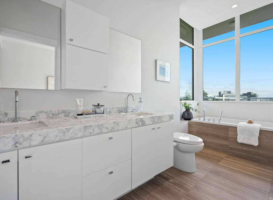 Experience modern luxury in this stunning bathroom featuring a sleek double vanity with marble countertops and contemporary fixtures.