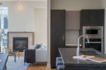Experience modern living in this stunning open-concept space, featuring a cozy fireplace and a sleek, contemporary kitchen.