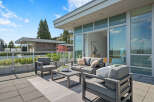 Experience luxurious outdoor living on this expansive patio, featuring a modern seating area with plush cushions and a stylish coffee table.