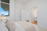 Experience modern living in this bright bedroom featuring a large window with city views and an en-suite bathroom.