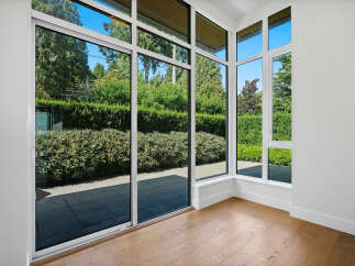 Experience seamless indoor-outdoor living with expansive floor-to-ceiling windows that flood this space with natural light.