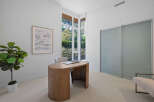 This modern home office features a sleek, curved wooden desk complemented by a comfortable upholstered chair.