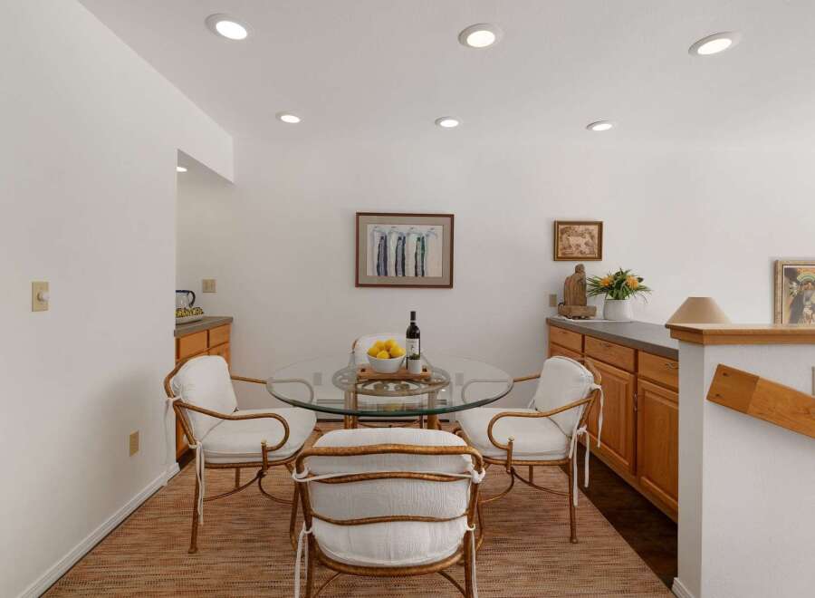 Enjoy intimate meals in this charming dining area, featuring a sleek glass-top table with four elegant chairs.